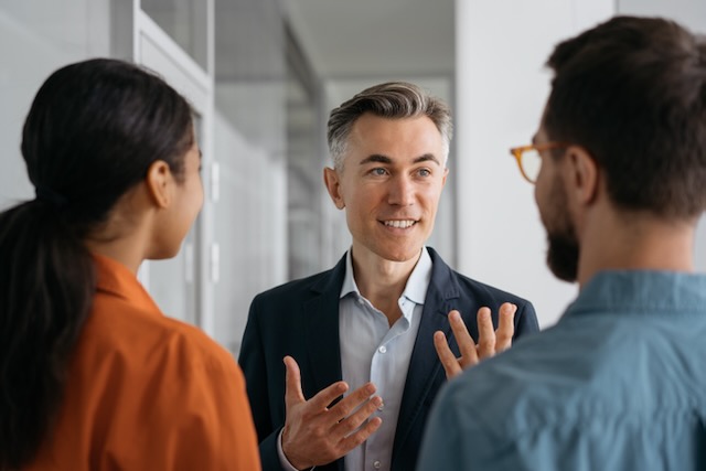 A mature mentor explaining a concept to his mentees.