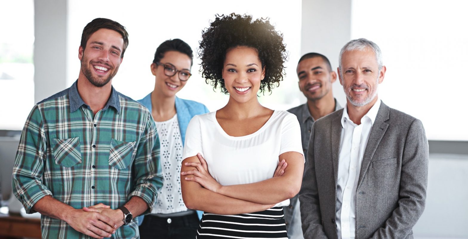 Portrait of a group of smiling coworkers standing in an office.