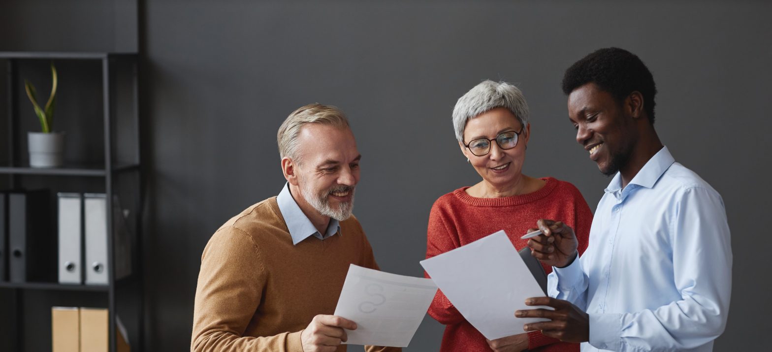 two men and a woman looking at documents together