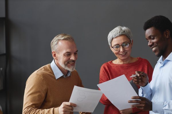 two men and a woman looking at documents together