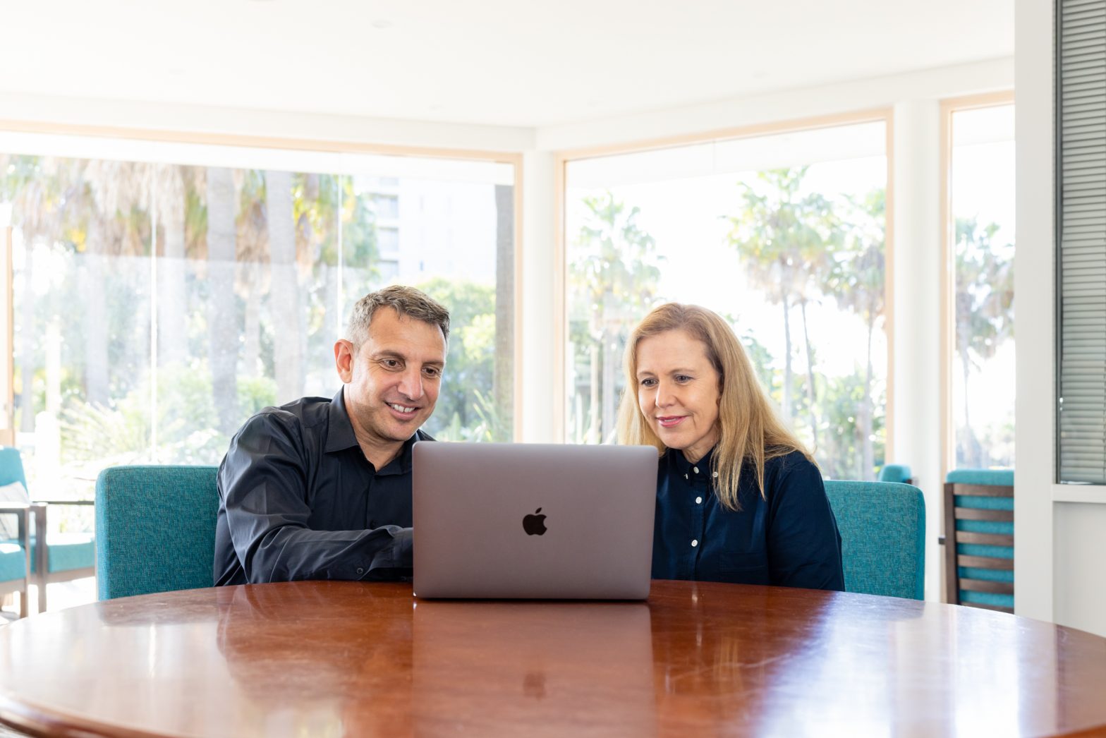 Two of the Art of Mentoring team looking at a laptop together.