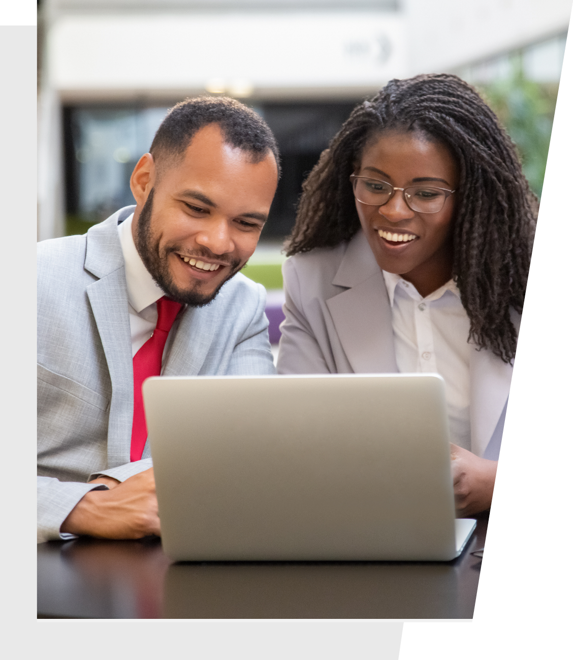 Male and female coworkers are looking at a laptop together.