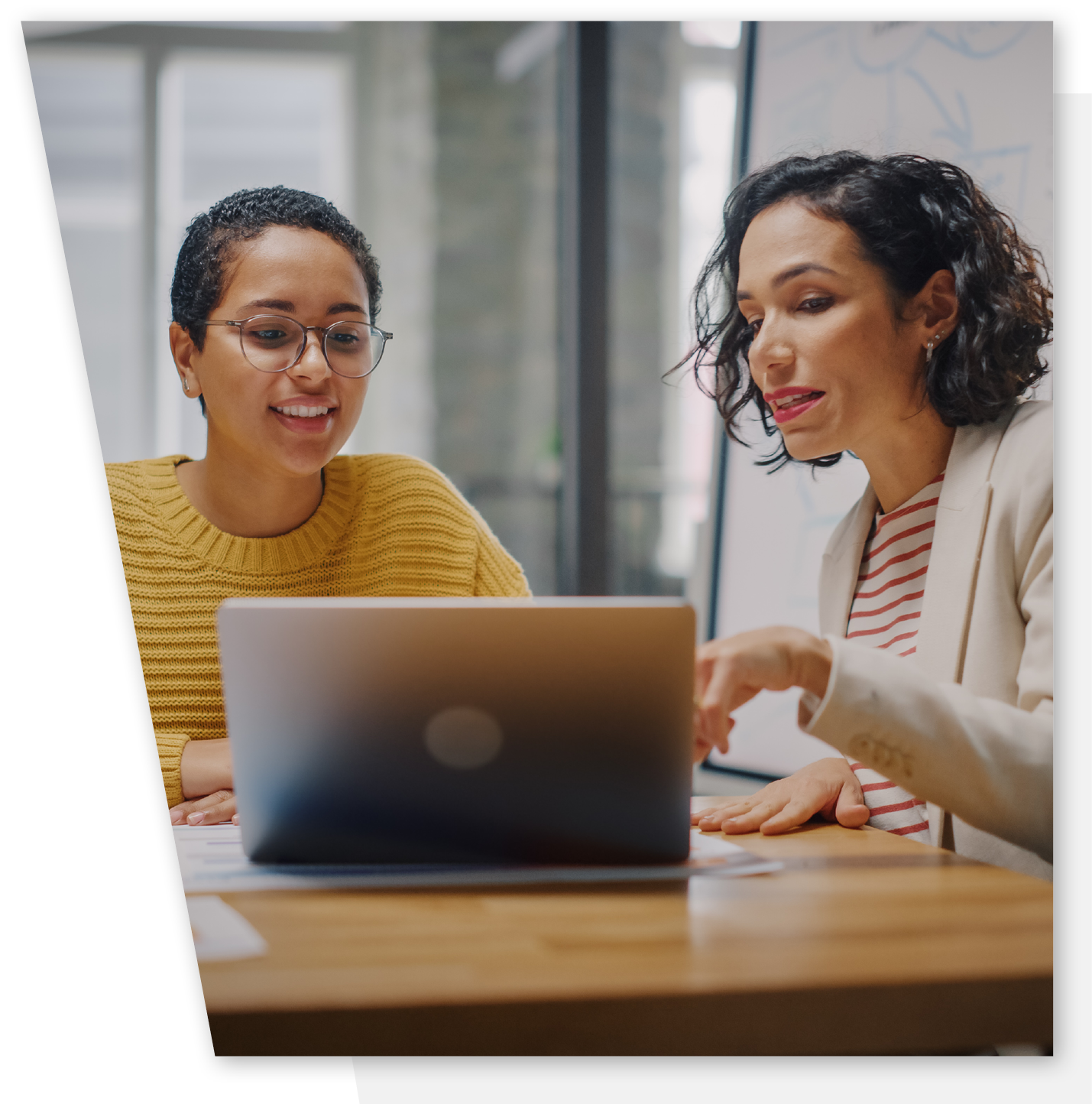 Mentor and mentee in discussion looking at a laptop