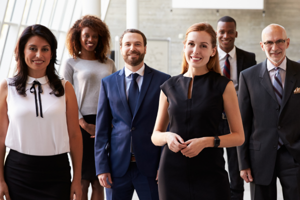 Male and female business people smartly dressed, smiling and posing.