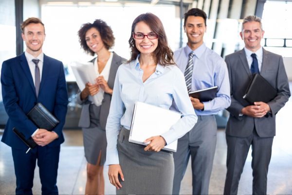 Business people smiling and posing holding notebooks and documents.